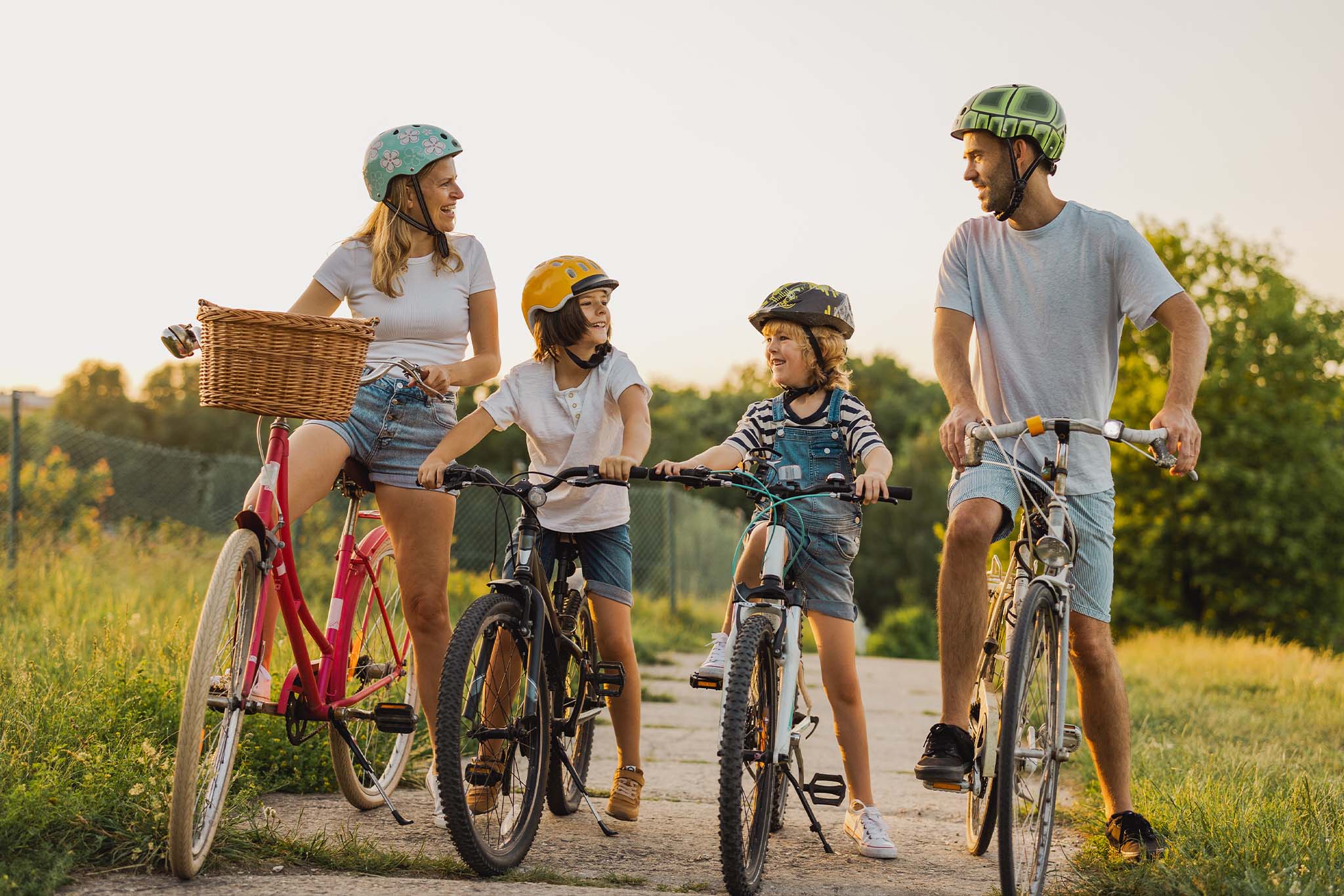 czteroosobowa rodzina w kaskach na wycieczce rowerowej